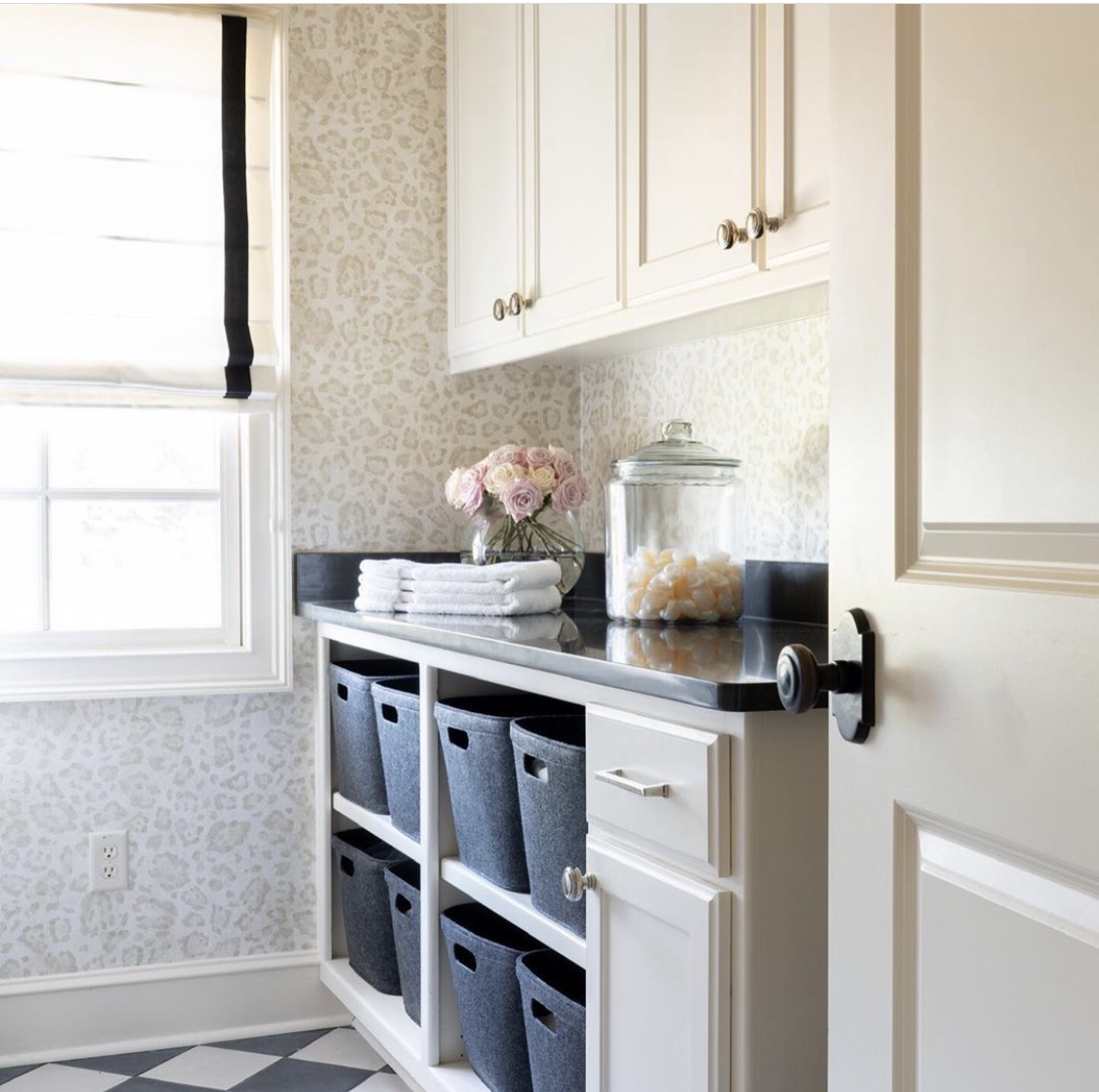 remodeled laundry room with checkerboard tile and animal print wallpaper
